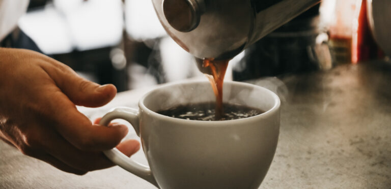 A cyclists pours a cup of coffee before a ride