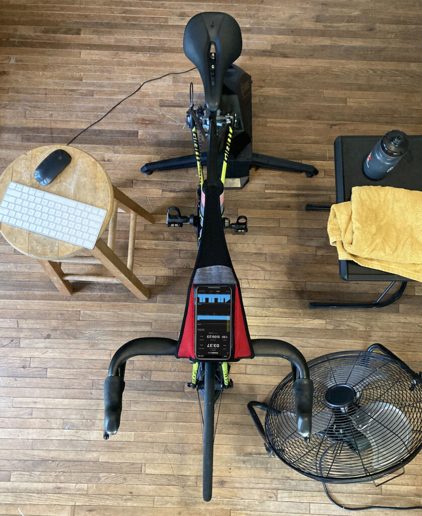 an indoor training setup including bike, indoor trainer, towel, and hydration