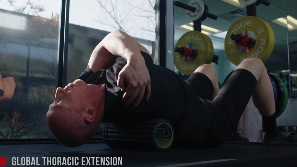 Coach Chad has a muscle roller underneath his upper back during this stretch for cyclists.
