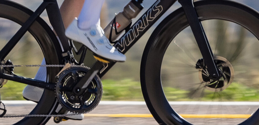 A cyclist rides on an expensive, aero-optimized bike.