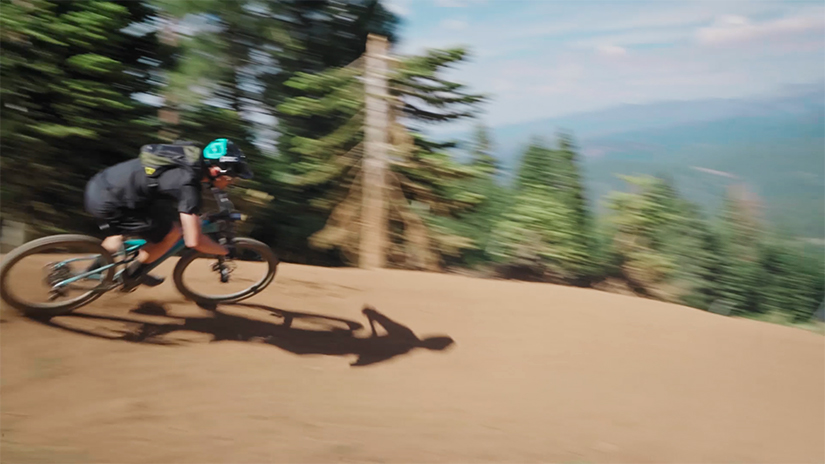 Jonathan maintains his speed in a bermed turn while riding his mountain bike.