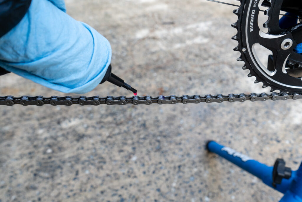A chain lube is being applied to a chain.