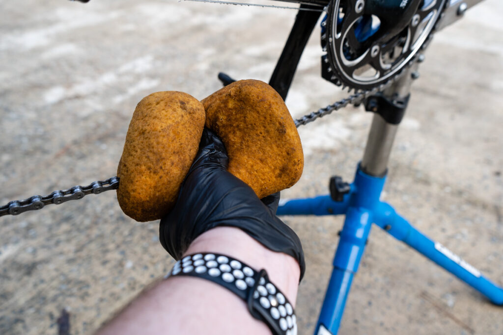 A sponge is being use to scube the chain and drivetrain.